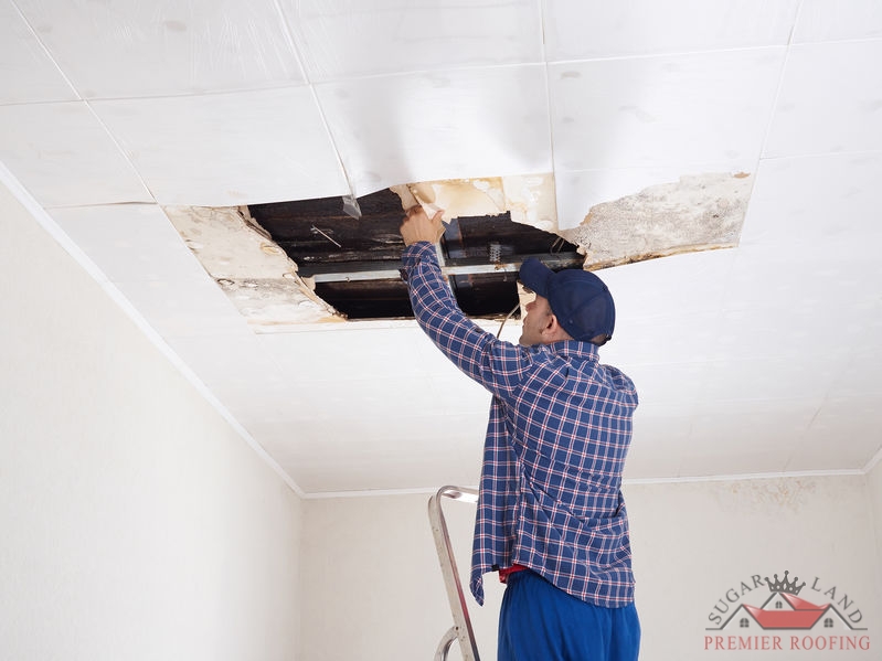 A Picture of a Man Repairing a Collapsed Ceiling.