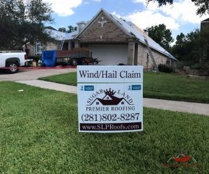 Sign In Yard With Roofers Installing Premium Roofing Materials On a House